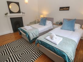 A bedroom with twin beds and a fireplace at Scillonia in Penzance