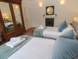 A bedroom with two beds and a mirror at Scillonia in Penzance
