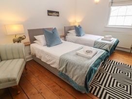 A bedroom with two beds and a chair at Scillonia in Penzance