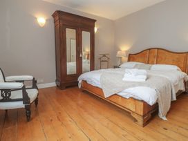 A bedroom with a wooden bed and wardrobe at Scillonia in Penzance