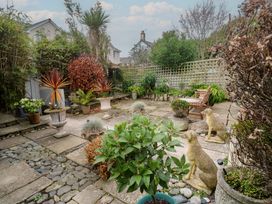 A garden with potted plants and a bench at Scillonia in Penzance