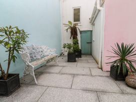 A garden with a bench and potted plants at Scillonia in Penzance