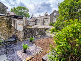 A garden with a table and chairs and plants at The Wonky Burrow in Bowness-On-Windermere