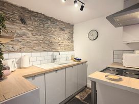 A kitchen with appliances and a stone wall at The Wonky Burrow in Bowness-On-Windermere