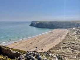 A beach with people walking near the water at Tower Cottage Near Pembroke