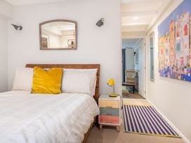 A bedroom with a bed, nightstand, mirror, and artwork at 14 Marine Parade in Lyme Regis
