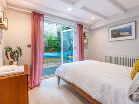 A bedroom with a bed and curtain leading to an outdoor area at 14 Marine Parade Lyme Regis