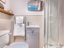 A bathroom with a sink, toilet, towel rack and shower at 14 Marine Parade Lyme Regis