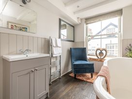 A bathroom with a sink, chair, and bathtub at 14 Marine Parade Lyme Regis