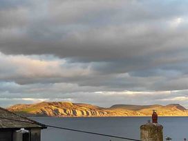 A view of hills and sea with clouds at 14 Marine Parade in Lyme Regis