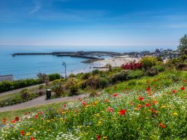 A view of a beach with flowers in the foreground at 14 Marine Parade Lyme Regis