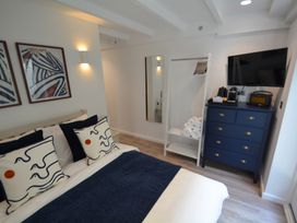 A bedroom with a bed and dresser at Port House in Lyme Regis