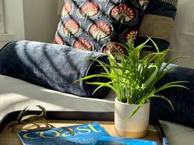 A living room with a plant and a magazine on a tray at Port House in Lyme Regis