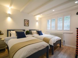 A bedroom with two beds and a window at Port House in Lyme Regis