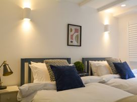 A bedroom with two beds and wall art at Port House in Lyme Regis