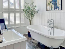 A bathroom with a bathtub and sink at Port House in Lyme Regis