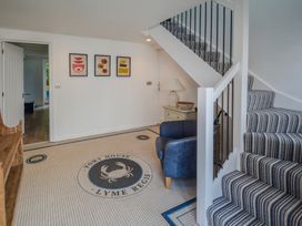 A hallway with stairs and artwork on the wall at Port House Lyme Regis