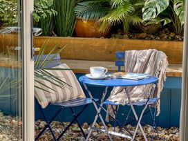 A garden setup with a blue table, chairs, and plants at Port House in Lyme Regis