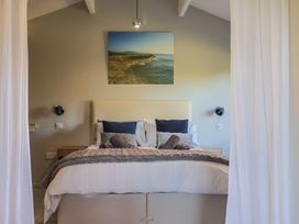 A bedroom with a bed and painting at Sir George Baker Cabin Uplyme