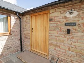 An entrance with a wooden door and stone wall at Keepers Barn in Bromyard