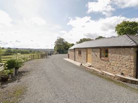 An outdoor view of a stone cottage with a gravel driveway at Keepers Barn Bromyard