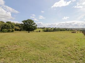 An outdoor view of a field with a tree and fence at Keepers Barn in Bromyard