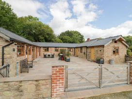 An outdoor area with a stone patio and table at The Cow Shed in Bromyard