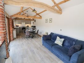 A living room with a sofa and dining area at The Cow Shed in Bromyard