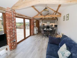 A living room with a sofa and dining area at The Cow Shed in Bromyard