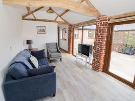 A living room with a sofa and television at The Cow Shed in Bromyard
