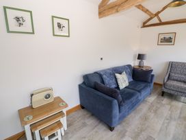 A living room with a sofa and a chair at The Cow Shed in Bromyard