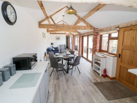 A living room with a dining table and sofa at The Cow Shed in Bromyard