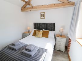 A bedroom with a bed and nightstand at The Cow Shed in Bromyard