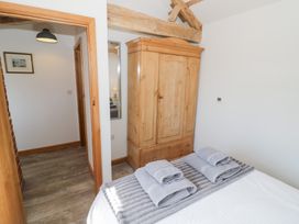 A bedroom with a wardrobe and towels on a bed at The Cow Shed in Bromyard