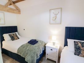 A bedroom with two beds and a bedside table at The Cow Shed in Bromyard