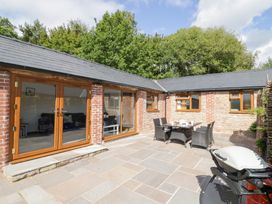 An outdoor seating area with a table and chairs at The Cow Shed in Bromyard