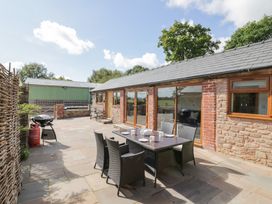 An outdoor patio with a dining table and chairs at The Cow Shed in Bromyard