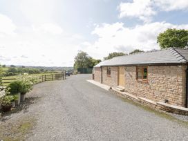 An outdoor area with a stone building and gravel pathway at The Cow Shed in Bromyard