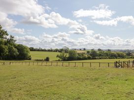 A field with trees and a fence at The Cow Shed in Bromyard