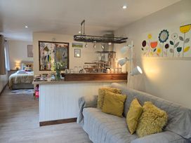 A living room with a sofa and kitchen area at Ty Barddu, Cwmorgan near Newcastle Emlyn