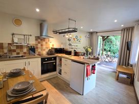 A kitchen with appliances and dining table at Ty Barddu in Cwmorgan near Newcastle Emlyn