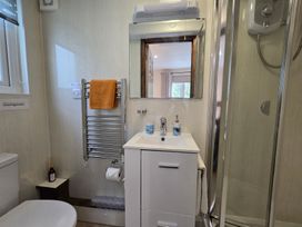 A bathroom featuring a sink, shower, and towel rack at Ty Barddu, Cwmorgan near Newcastle Emlyn