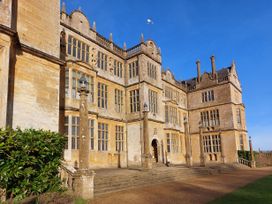 A large historic building with multiple windows and stone pillars at Two Towers Cottage Montacute