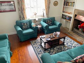A living room with sofas, armchairs, coffee table and a fireplace at Two Towers Cottage in Montacute