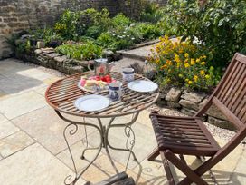 A garden with a table set for tea at Two Towers Cottage in Montacute