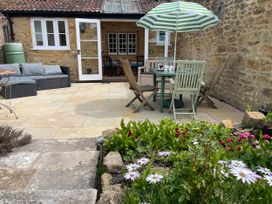 A garden with seating and table at Two Towers Cottage in Montacute