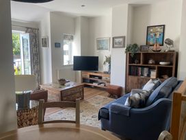 A living room with a sofa, coffee table, television and bookshelf at Hamnavoe in Stoke Fleming