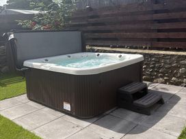 A hot tub with steps in a garden at Yr Hen Stabl, Llanwnda near Bontnewydd, Gwynedd
