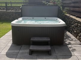A hot tub with steps on a patio at Yr Hen Stabl Llanwnda near Bontnewydd Gwynedd