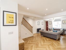 A living room with a staircase and a sofa at Neptune Cottage in Conwy